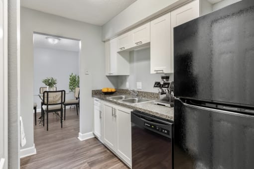 a kitchen with white cabinetry and black appliances  at Mirabelle Apartments in Mobile, Alabama