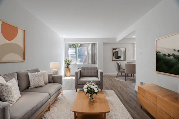 A living room with a grey couch, a wooden coffee table, and a painting on the wall.at 161 St. George, Toronto California