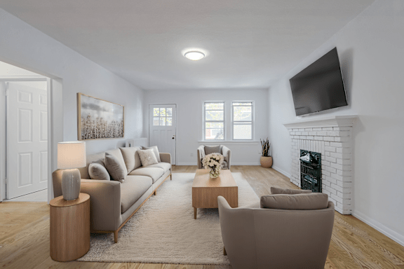 A living room with a fireplace and a television mounted on the wall.at 83-85 Silver Birch, Toronto California