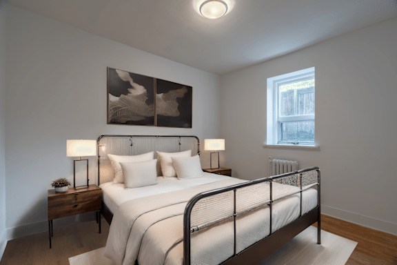 A bedroom with a bed, nightstand, and two lamps. at 391 Sherbourne Apartments, Toronto, ON, M4X 1K4