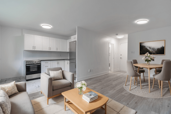 A modern living room with a grey couch, a wooden coffee table, and a dining table set up. at 177 Saint George in Toronto, CA