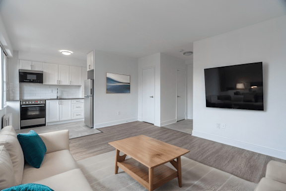 A modern living room with a wooden coffee table and a flat screen TV mounted on the wall.at 161 St. George, Toronto