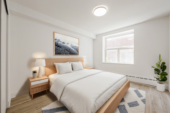 A bedroom with a large bed and a painting on the wall.at 111 Cosburn, Ontario