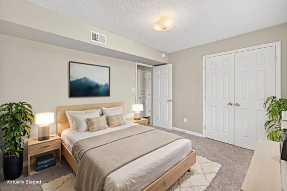 A bedroom with a large bed and a painting on the wall.