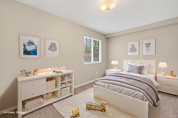A bedroom with a bed, nightstands, and a dresser with toys on top.