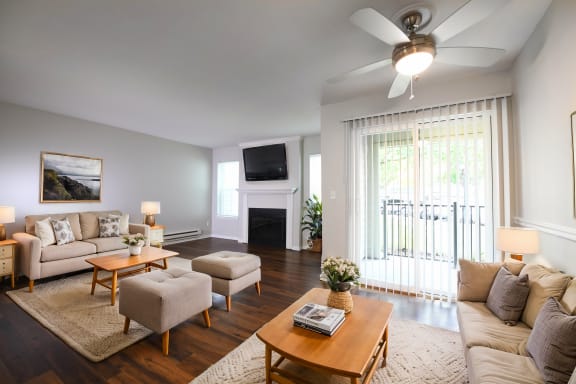 a living room with couches and a table and a ceiling fan