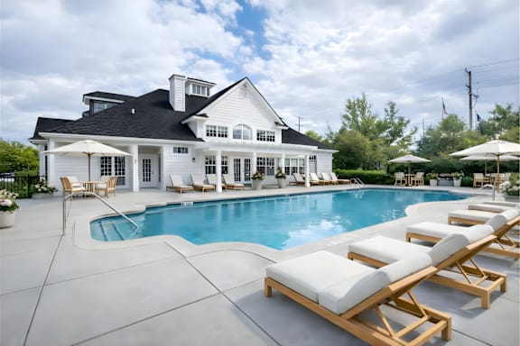A large white house with a pool in front.