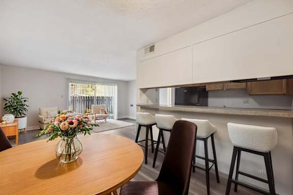 A dining room with a wooden table and chairs.