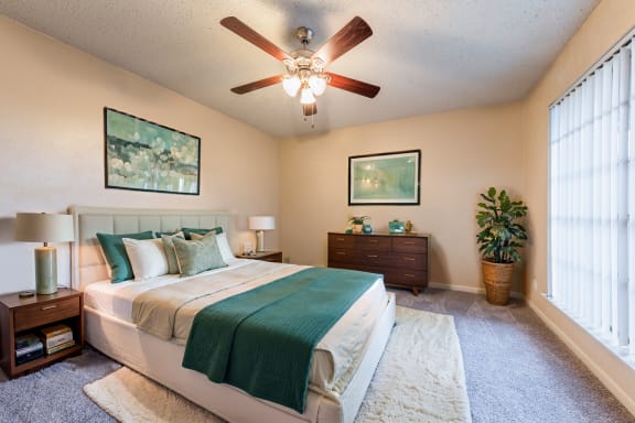 a bedroom with a bed and a ceiling fan