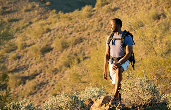 a man with a backpack standing on a hillside