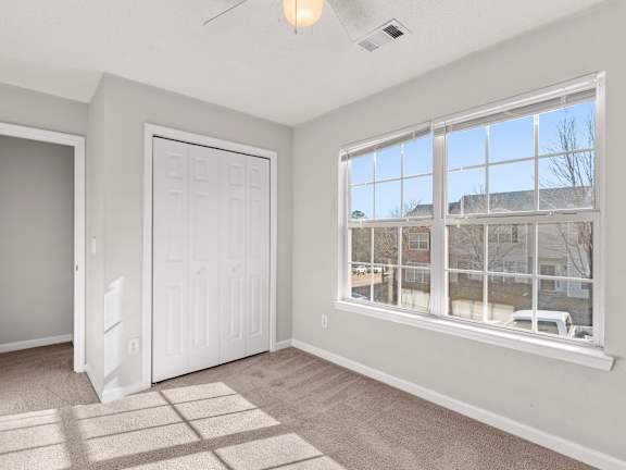 A room with a large window and a car parked outside.