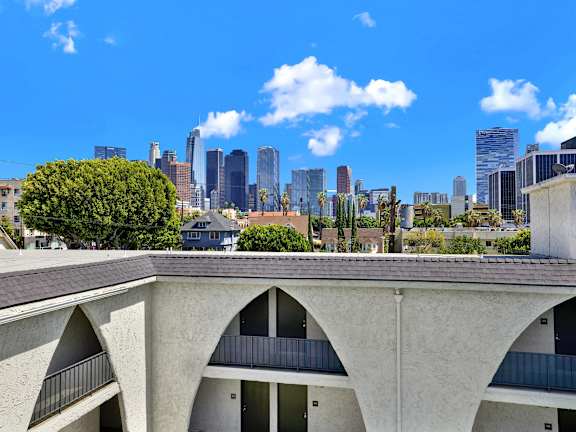 A concrete building with arched windows overlooks a city skyline. at Bonnie Brae Apartments, California