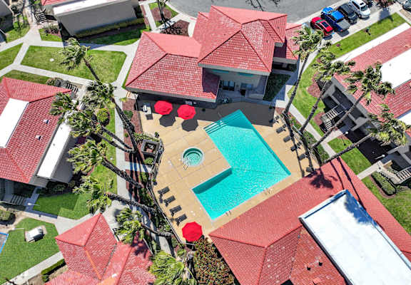 A red roofed house with a swimming pool in the backyard.