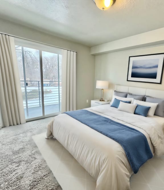 a bedroom with a bed and a sliding glass door