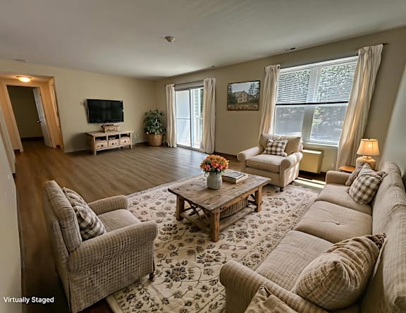 A living room with a couch, chairs, and a coffee table.