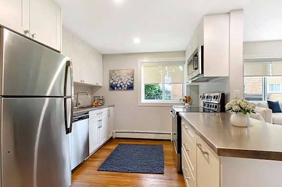 A kitchen with a refrigerator, microwave, and oven.