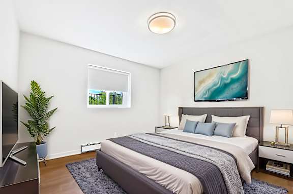 A bedroom with a large bed and a painting on the wall.