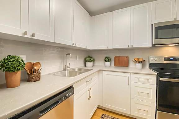 A kitchen with white cabinets and a black oven.