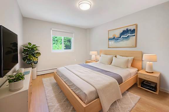 A bedroom with a bed, nightstands, and a painting on the wall.