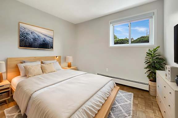 A bedroom with a large bed and a painting on the wall.