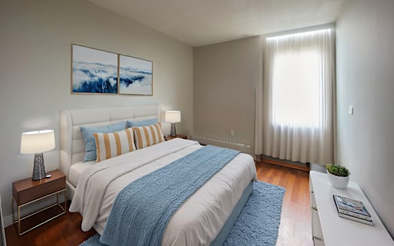 A bedroom with a large bed and a painting on the wall.