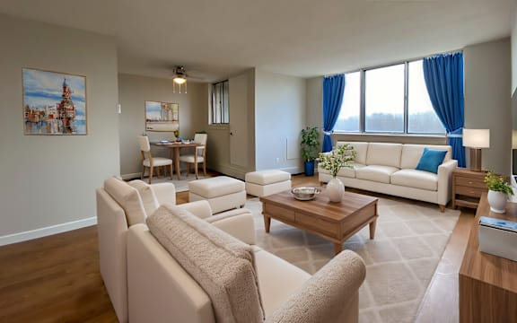 A living room with a white couch, a coffee table, and a painting on the wall.
