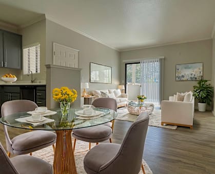 A modern dining room with a glass table and chairs. at Sharlands Terrace Apartments, Reno, 89523