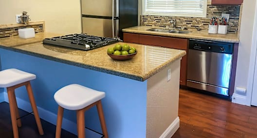 A kitchen with a blue counter and a stove.