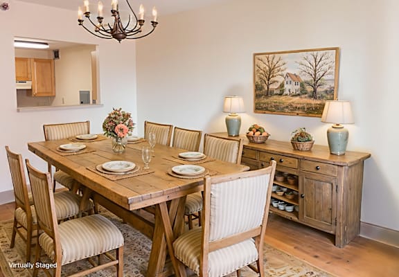 A dining room with a wooden table and chairs.
