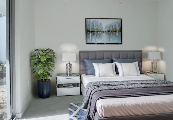 a bedroom with a bed and a plant at Meridian Point at Goulds Station in Miami, FL, 33170