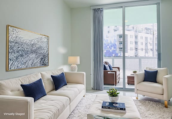 a living room with a large window and a couch and a table at Meridian Point at Goulds Station in Miami, FL, 33170