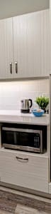 A kitchen with white cabinets and a stainless steel refrigerator
