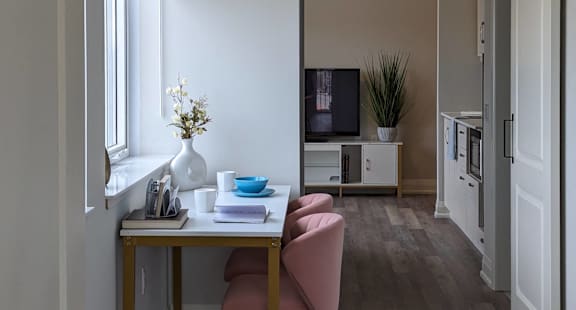 a dining room with a table and a chair and a window