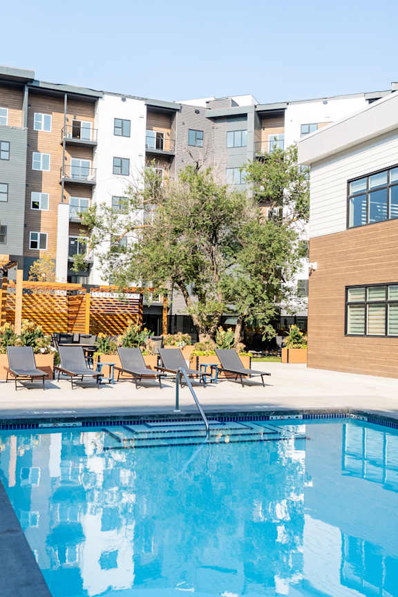 A swimming pool in front of a multi-story apartment building.