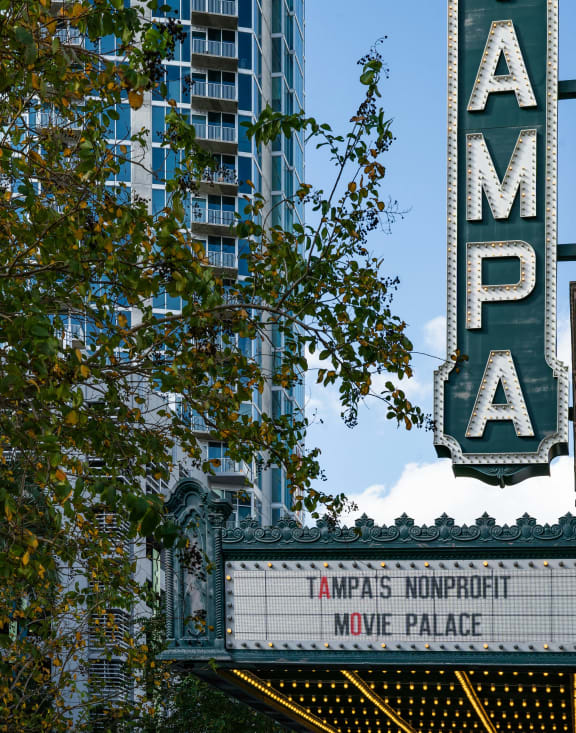 a sign for the amas nominated movie palace in front of a tall building