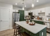 Thumbnail 2 of 33 - a kitchen with green and white cabinets and a white counter top at Edgebrook Residences, New Hampshire
