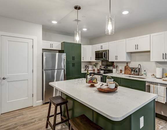 a kitchen with green and white cabinets and a white counter top at Edgebrook Residences, New Hampshire