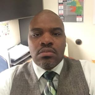 a man wearing a vest and tie in an office