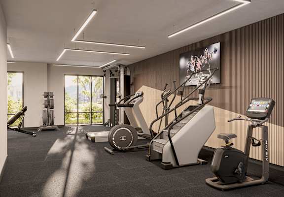 A gym with a variety of equipment including treadmills, weights, and exercise machines.