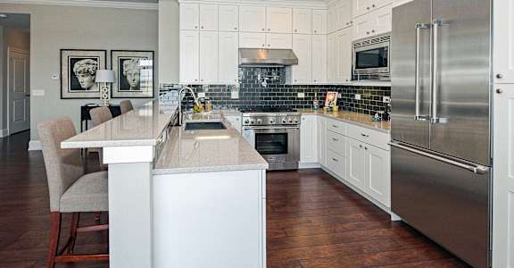 a large white kitchen with stainless steel appliances and a counter top