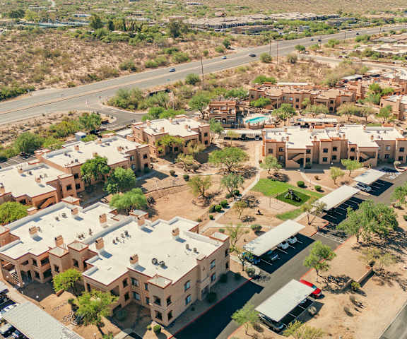 A road runs through a desert community with houses on either side.