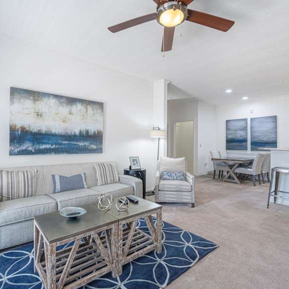 a living room with blue couches and chairs and a fireplace
