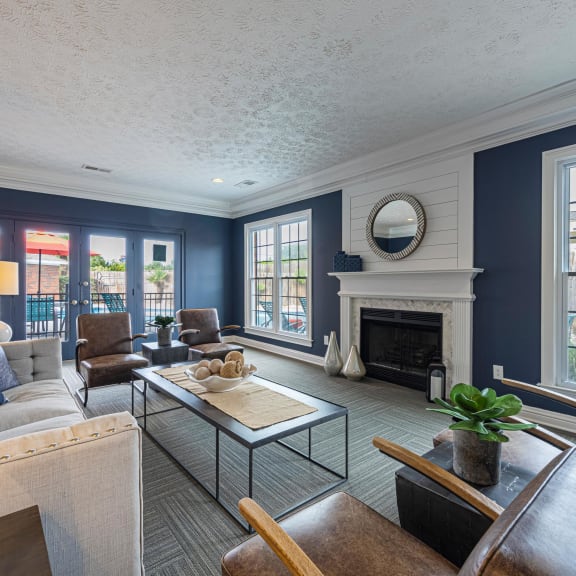 a living room with blue couches and chairs and a fireplace