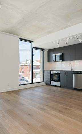 A kitchen with a refrigerator, oven, and microwave.