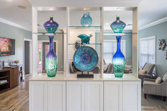 a living room with blue and green vases on a shelf
