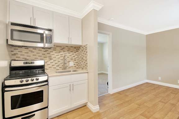 A kitchen with white appliances and cabinets.