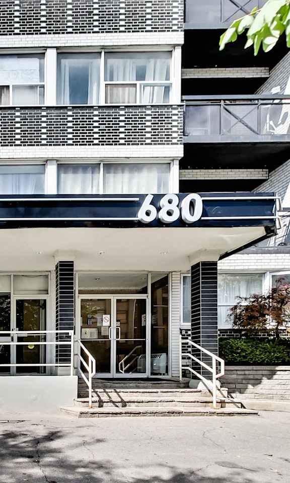 the front of a condo building with stairs and a ramp