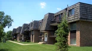 A row of houses with a green lawn in front.