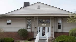 A house with a grey roof and a white door.