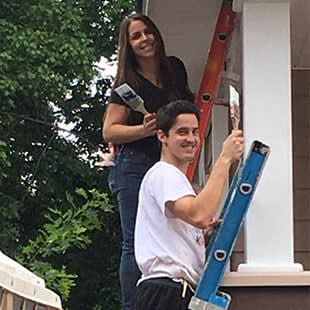 a man holding a ladder up to a window